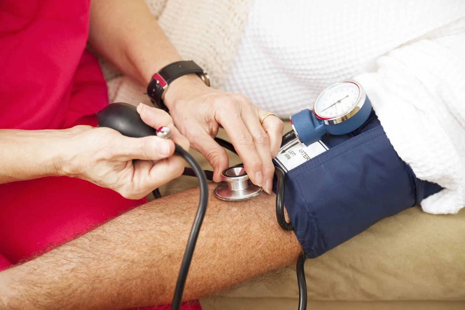 nurse measuring a patient's blood pressure because high blood pressure is a side effect of ketamine use