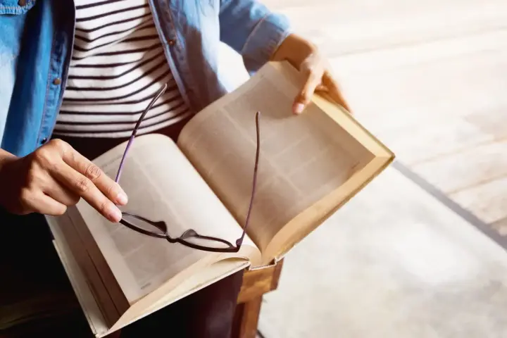 Books About Addiction: A person sitting in a chair reading a book.