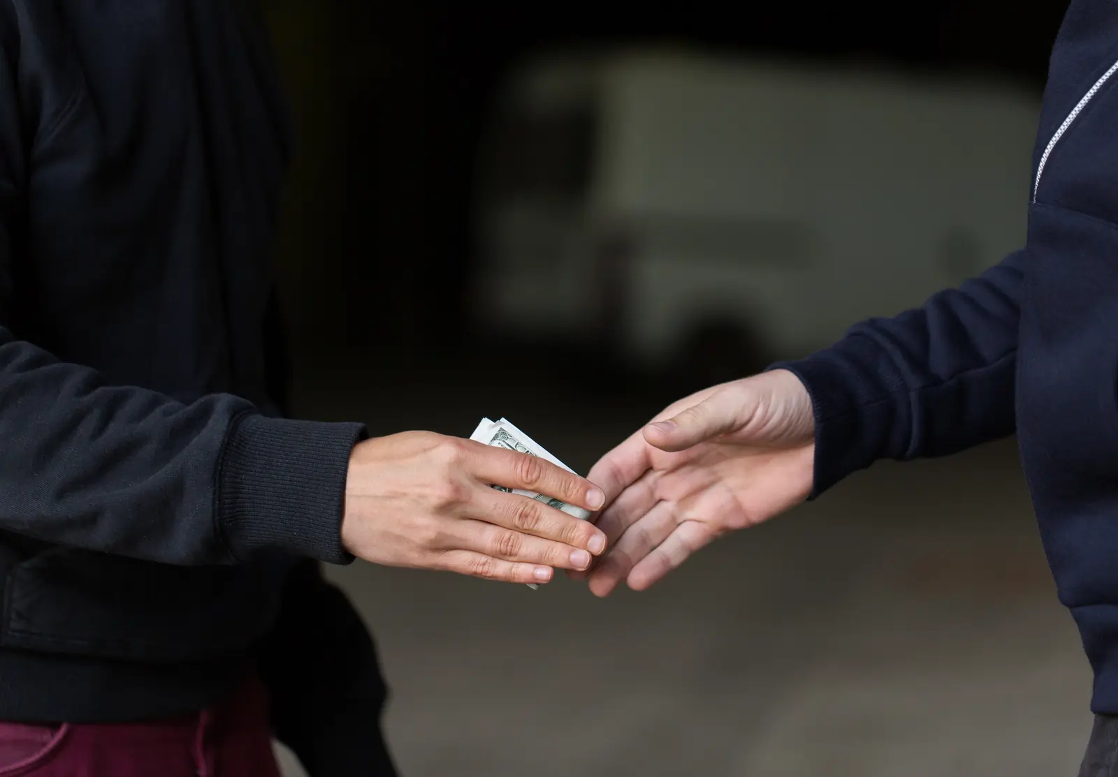 close up of addict paying money to drug dealer on street
